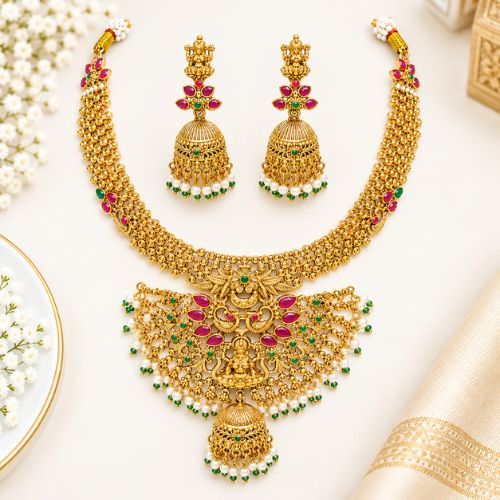 Gold-tone finish with ruby-red and green stonesLakshmi Temple Jewellery